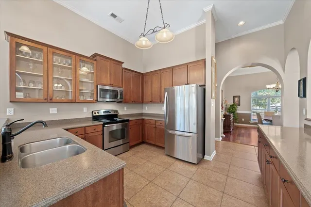 a kitchen with stainless steel appliances granite countertop a refrigerator a sink dishwasher a stove with wooden cabinets and floor