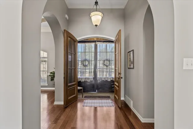 a view of a hallway with wooden floor and staircase
