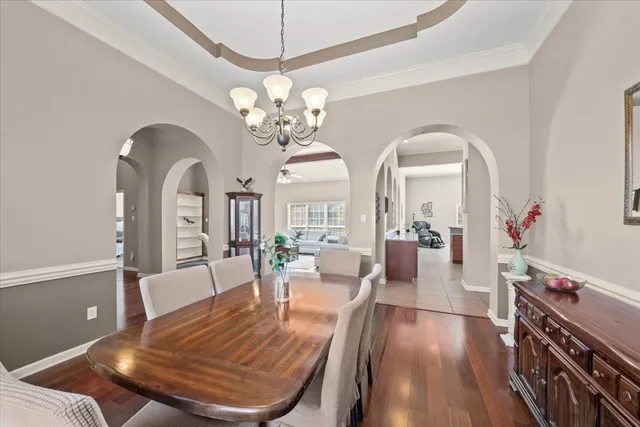 a view of a dining room with furniture a chandelier and wooden floor