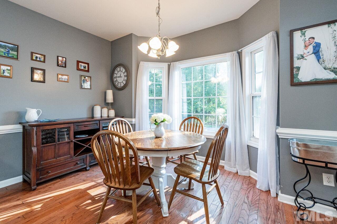 2409 Trout Stream Drive Raleigh, NC 27604 - Photo 14 of 27 a dining room with furniture a chandelier and wooden floor