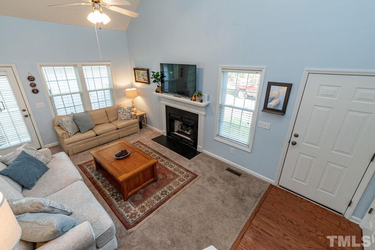 2409 Trout Stream Drive Raleigh, NC 27604 - Photo 8 of 27 a living room with furniture a flat screen tv and a fireplace
