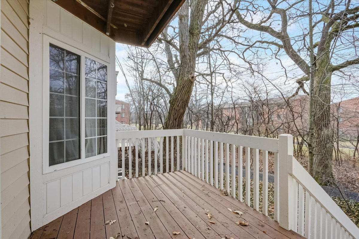 337 West Treehouse Lane, Unit 112 Round Lake, IL 60073 - Photo 5 of 33 a balcony with wooden floor and fence