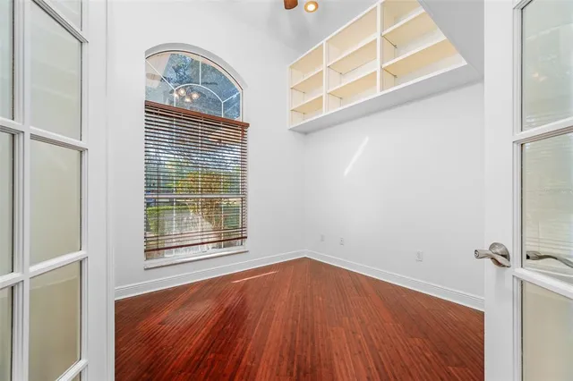 a kitchen with stainless steel appliances granite countertop a sink a stove top oven a chimney wooden floor and cabinets