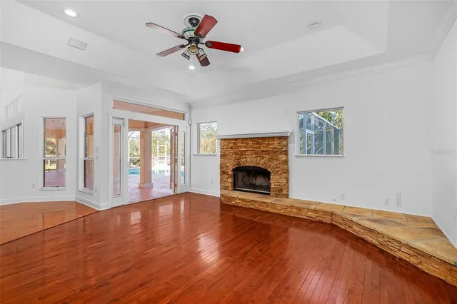 a view of an empty room with a window and wooden floor