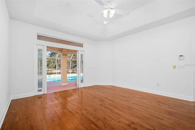 a view of a house with a big yard and palm trees