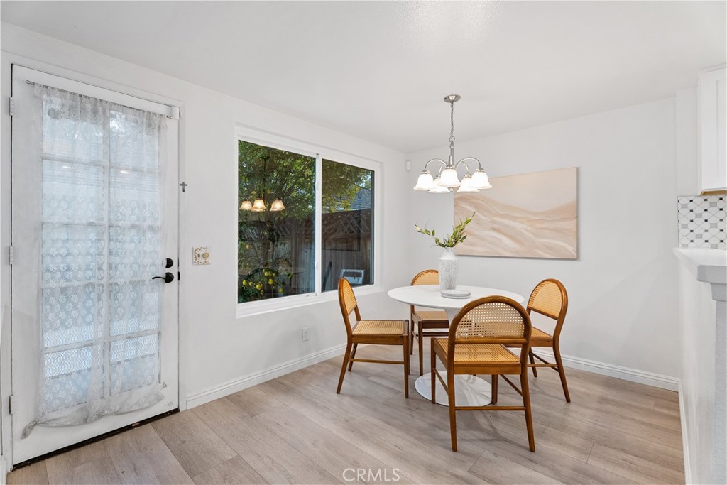16 East Yale Loop, Unit 28 Irvine, CA 92604 - Photo 11 of 44 a dining room with furniture a chandelier and wooden floor
