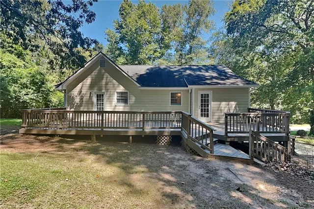 a view of a house with a small yard and wooden fence
