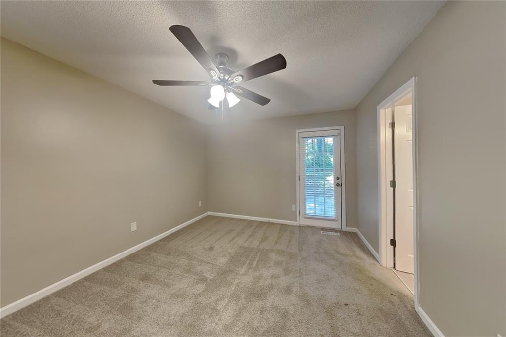 5394 Muirwood Place Powder Springs, GA 30127 - Photo 7 of 18 an empty room with chandelier fan and windows