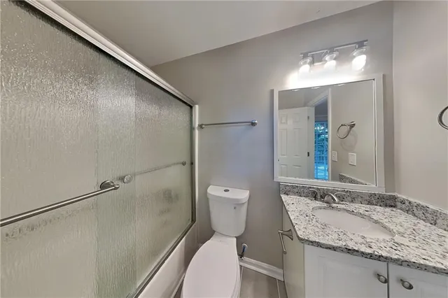 a bathroom with a granite countertop sink toilet and shower