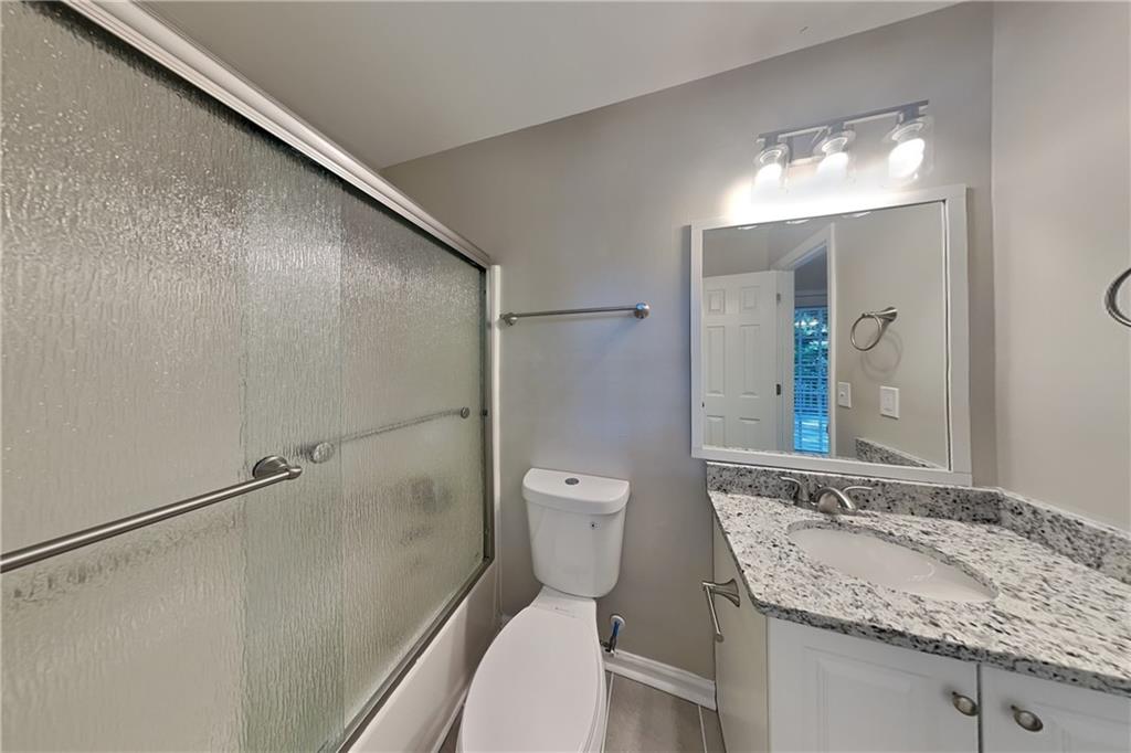 5394 Muirwood Place Powder Springs, GA 30127 - Photo 9 of 18 a bathroom with a granite countertop sink toilet and shower