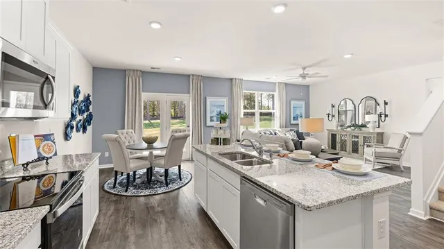 a kitchen with stainless steel appliances kitchen island granite countertop a sink and cabinets