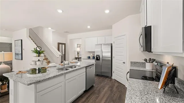 a kitchen with stainless steel appliances granite countertop a sink stove and refrigerator