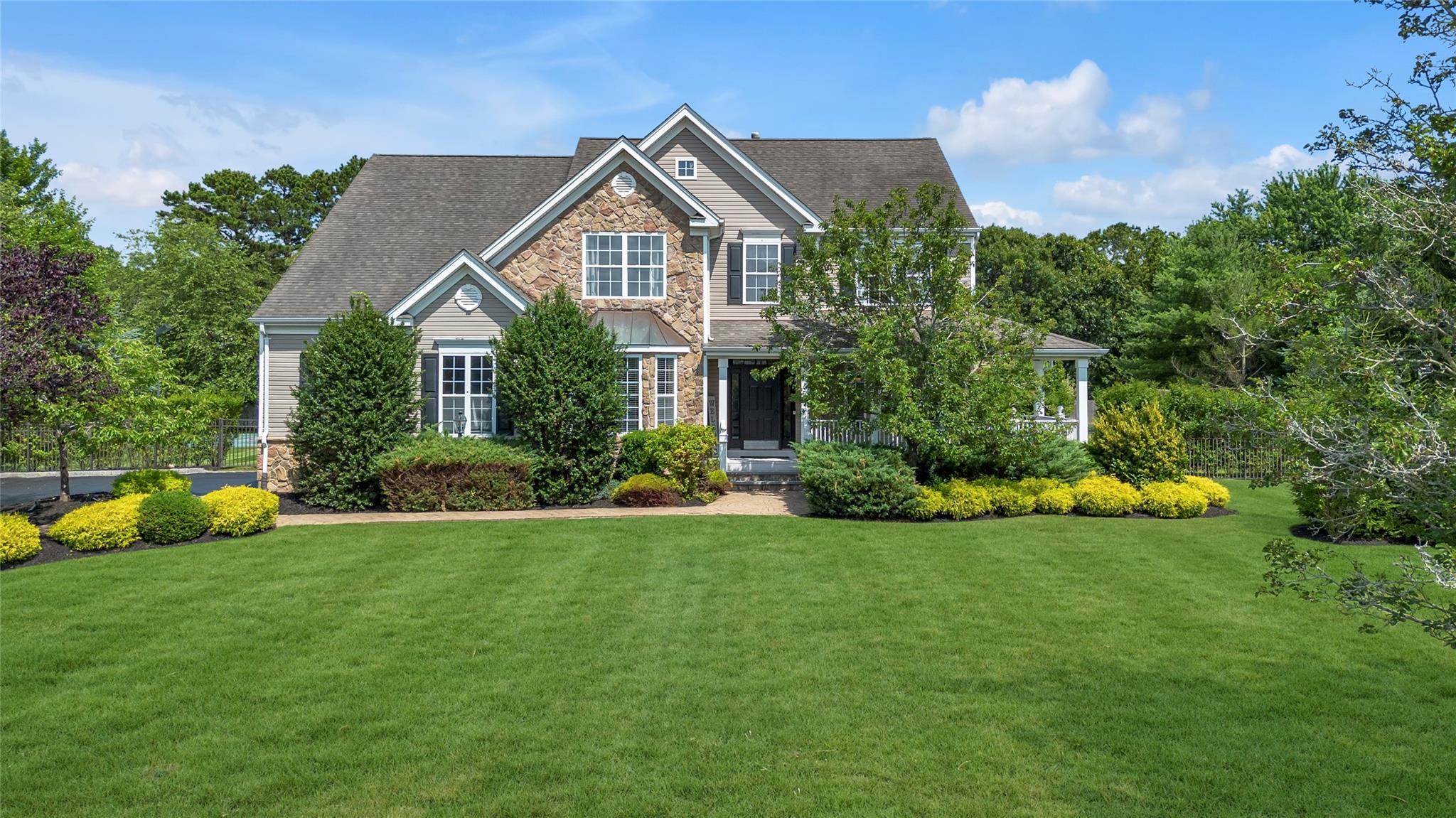 265 Hidden Acres Path Wading River, NY 11792 - Photo 39 of 46 View of front facade featuring stone siding, a front yard, and roof with shingles