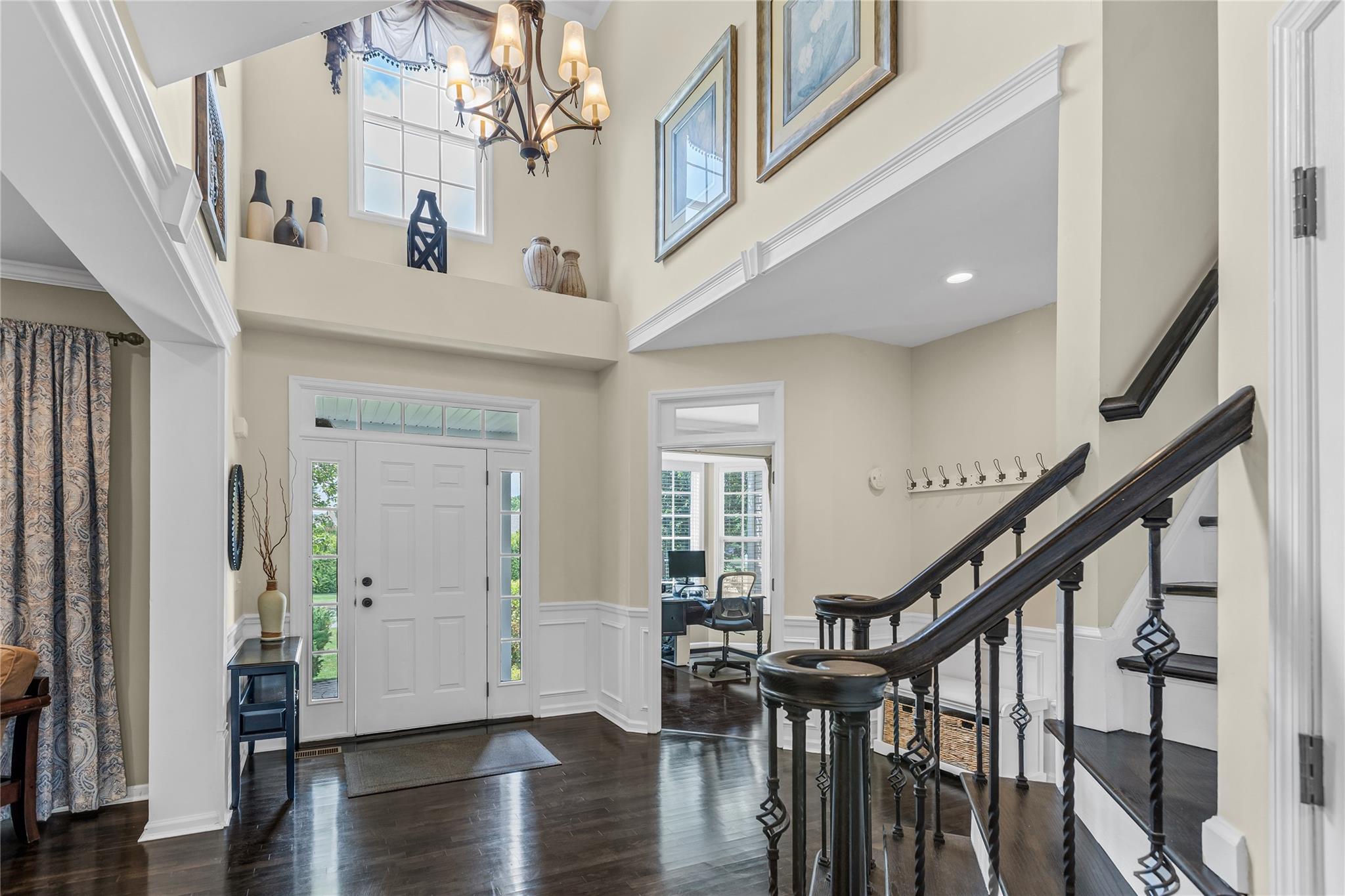 265 Hidden Acres Path Wading River, NY 11792 - Photo 5 of 46 Entryway with dark wood finished floors, wainscoting, a chandelier, stairway, and a high ceiling