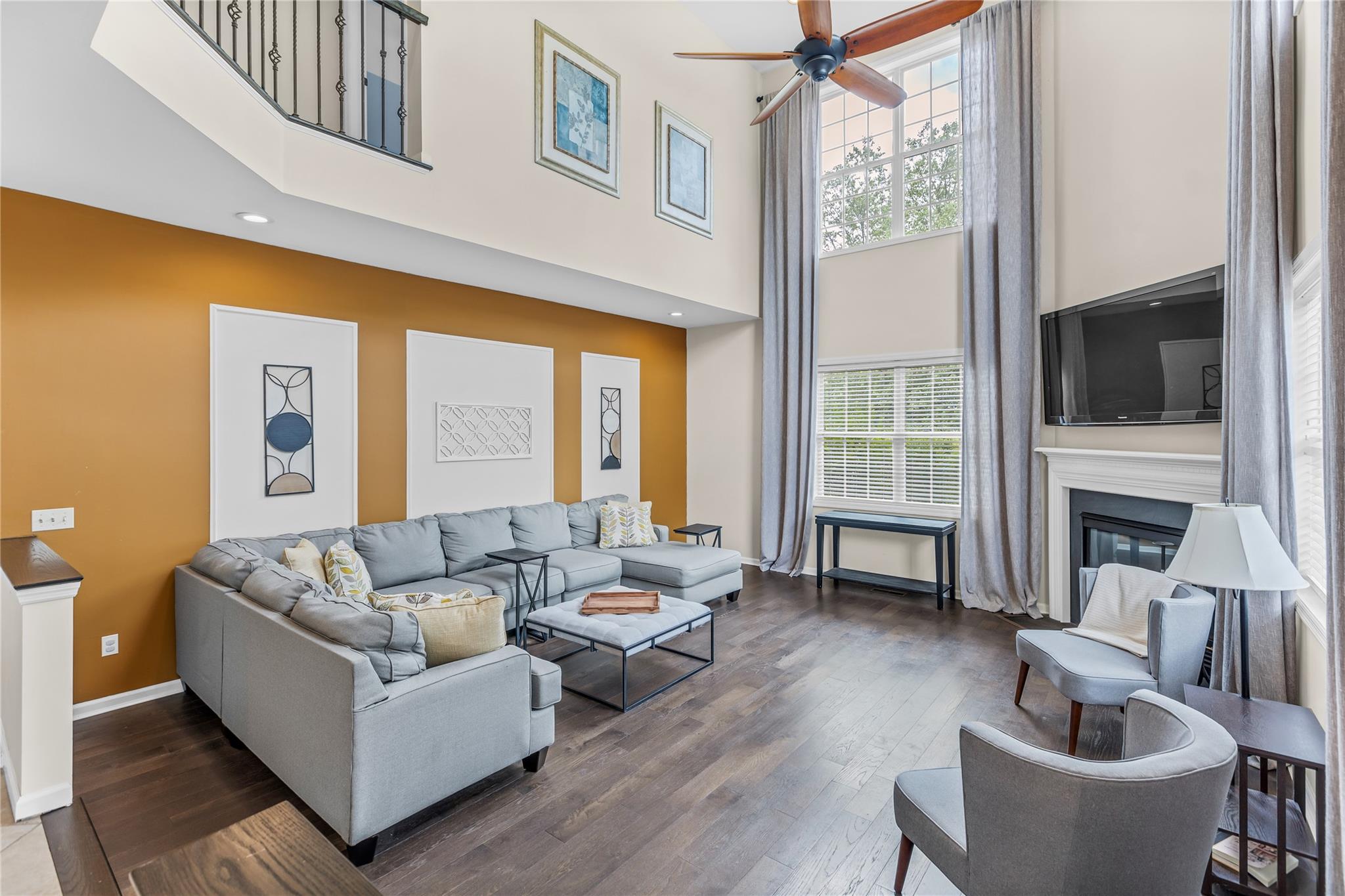 265 Hidden Acres Path Wading River, NY 11792 - Photo 10 of 46 Living area featuring a high ceiling, a ceiling fan, wood finished floors, and a glass covered fireplace