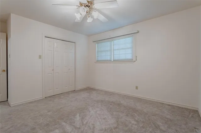 an empty room with a chandelier fan