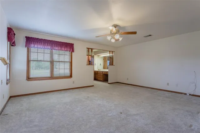 an empty room with windows and ceiling fan view
