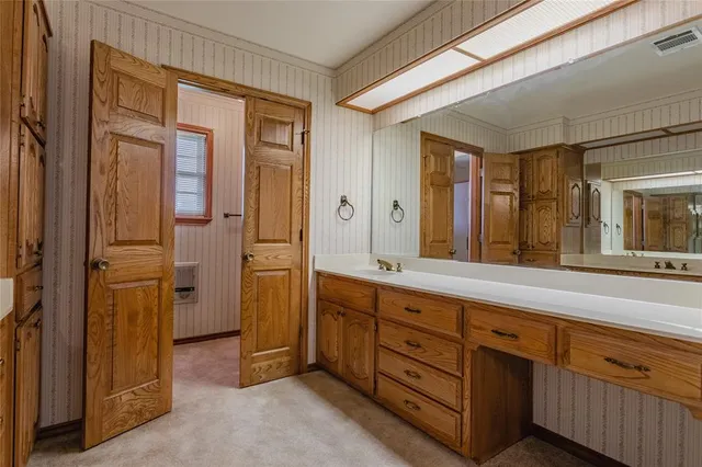 a spacious bathroom with a double vanity sink a large mirror and a shower