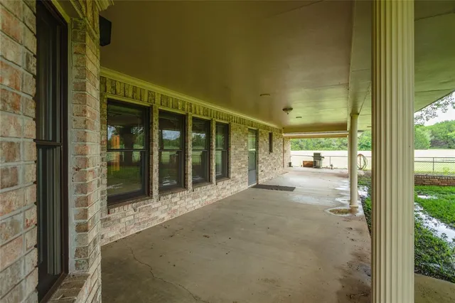 a view of a porch with a table and chairs