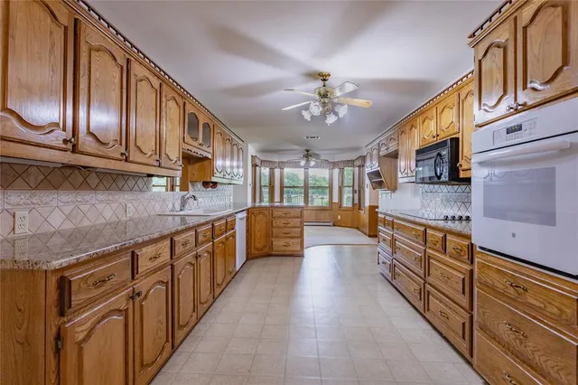 a large kitchen with stainless steel appliances granite countertop a large stove top oven
