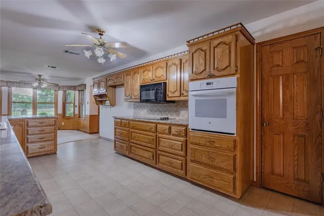 a spacious bathroom with a granite countertop sink a mirror and shower