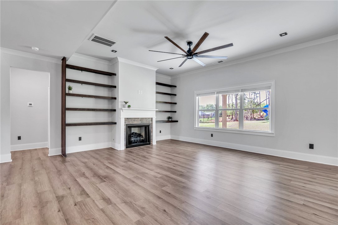 226 Holly Br Road Piedmont, SC 29673 - Photo 5 of 44 An inviting living area with warm wood-style flooring and a stately fireplace flanked by built-in shelves.