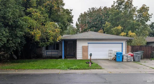 a front view of a house with a garden and plants