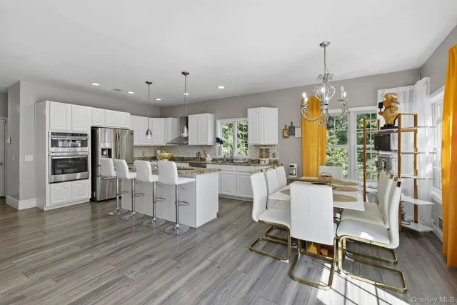 a open kitchen with white cabinets and stainless steel appliances