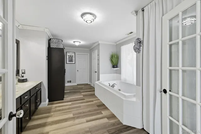 a bathroom with a tub sink and mirror