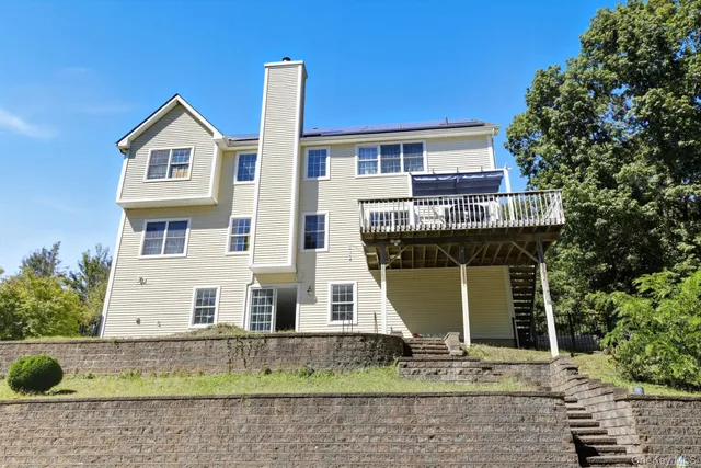a view of a white house with large windows and a small yard