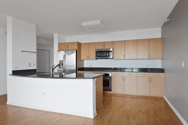 a kitchen with stainless steel appliances granite countertop a sink stove and microwave