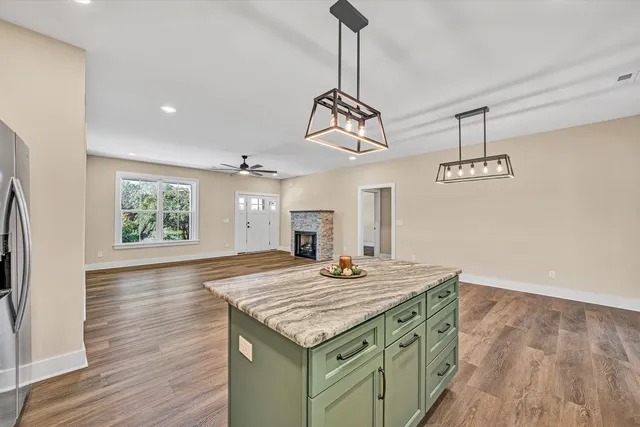a kitchen area with granite countertop stove and wooden floor