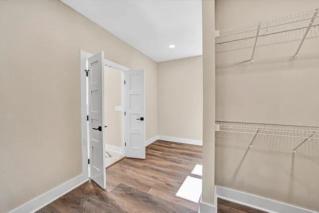 a view of walk in closet with wooden floor