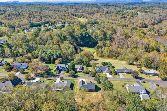an aerial view of a house with swimming pool and yard