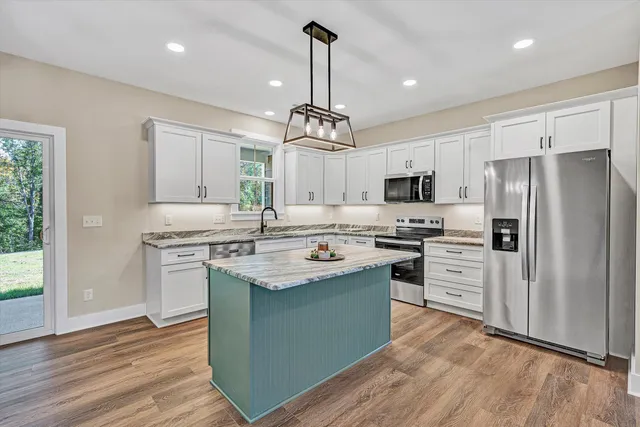 a kitchen with stainless steel appliances granite countertop a sink stove and refrigerator