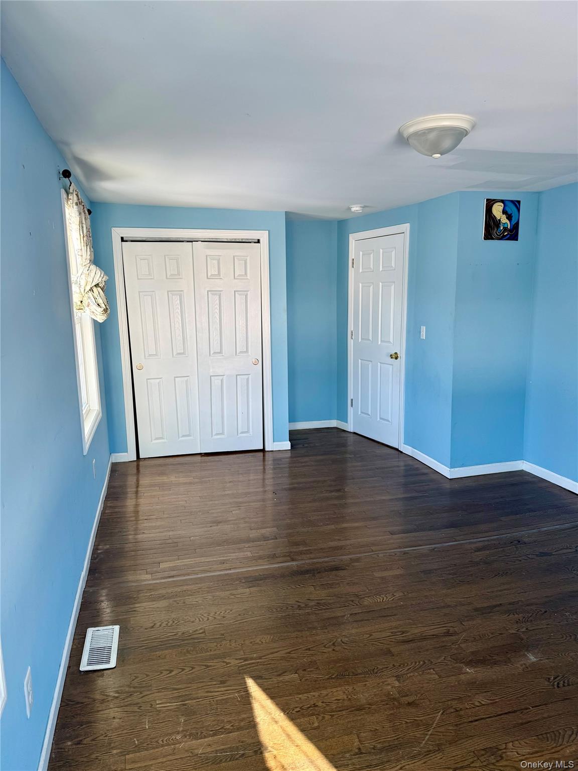 47 College Road Selden, NY 11784 - Photo 5 of 15 Unfurnished bedroom with dark wood finished floors and a closet