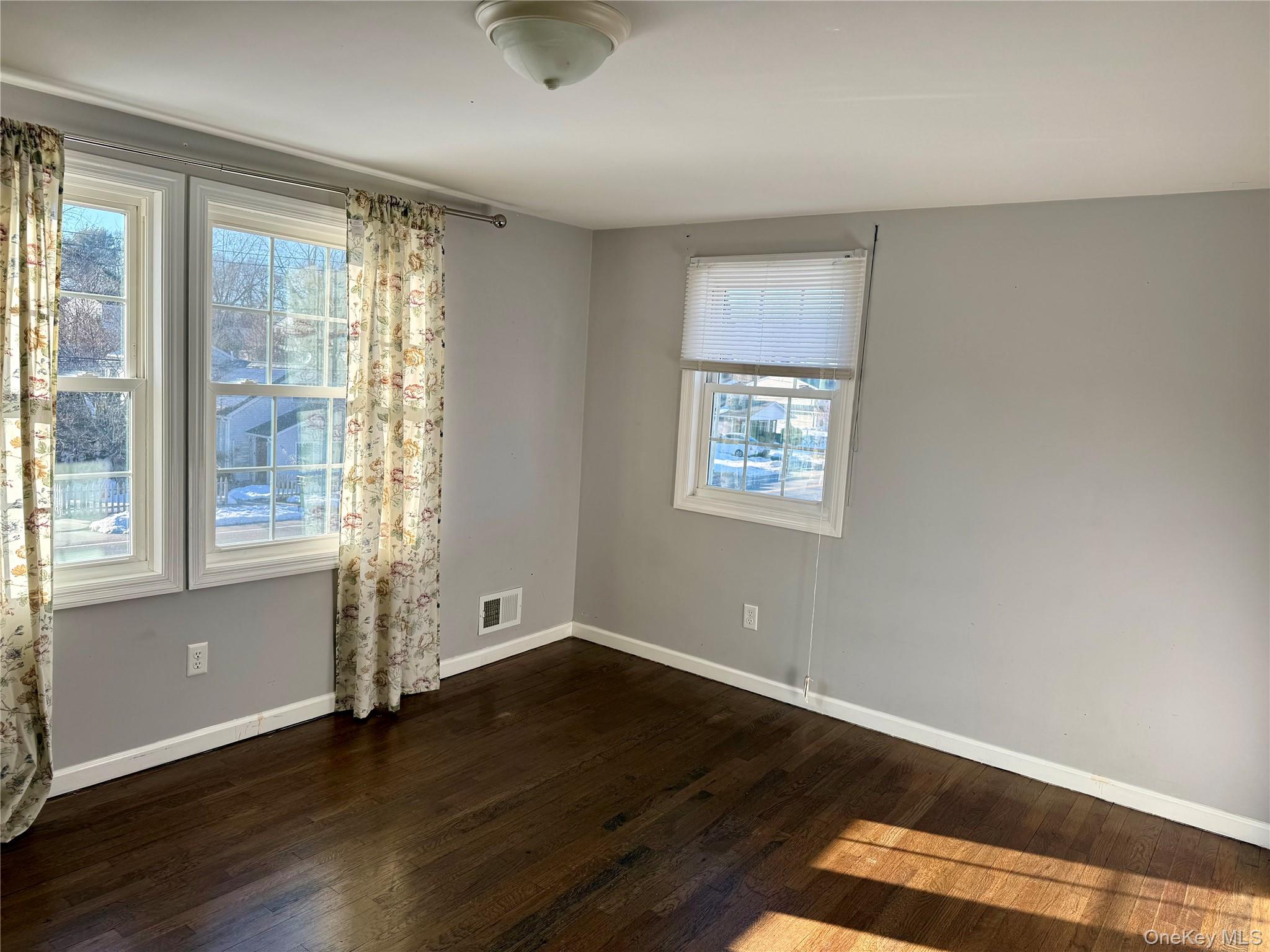 47 College Road Selden, NY 11784 - Photo 6 of 15 Unfurnished room with dark wood finished floors and baseboards