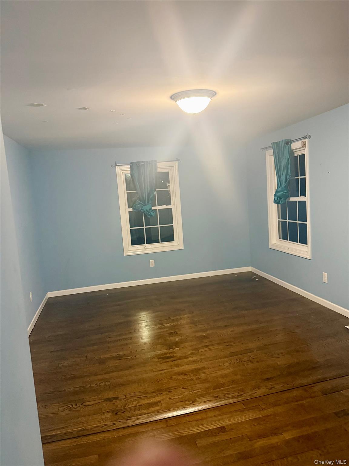 47 College Road Selden, NY 11784 - Photo 10 of 15 Spare room featuring dark wood-style flooring and baseboards