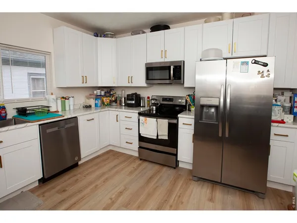 a kitchen with white cabinets and stainless steel appliances