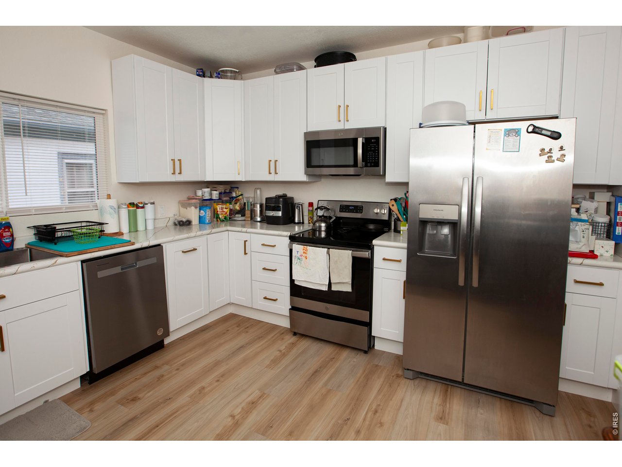 212 Denver Street Sterling, CO 80751 - Photo 14 of 30 a kitchen with white cabinets and stainless steel appliances
