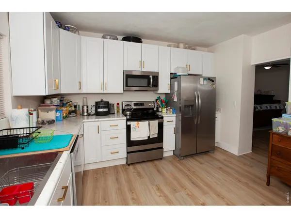 a kitchen with white cabinets and stainless steel appliances