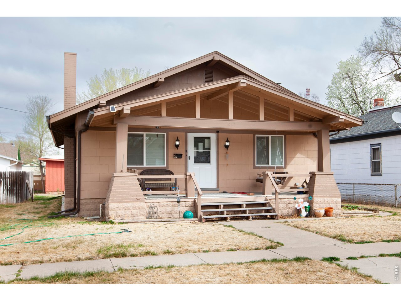 212 Denver Street Sterling, CO 80751 - Photo 2 of 30 a front view of a house with a yard outdoor seating and barbeque oven