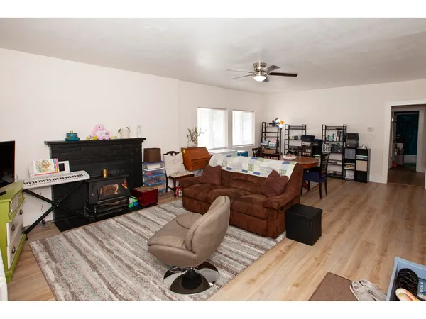 a living room with furniture a fireplace and wooden floor