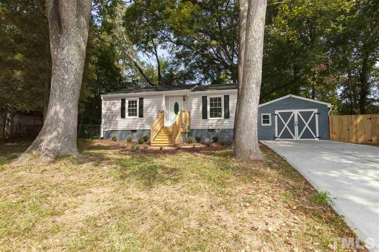 a view of a house with backyard and trees