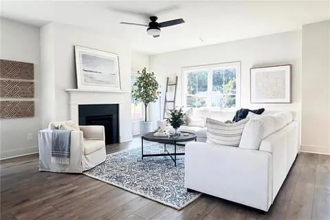 a living room with furniture a fireplace and large windows