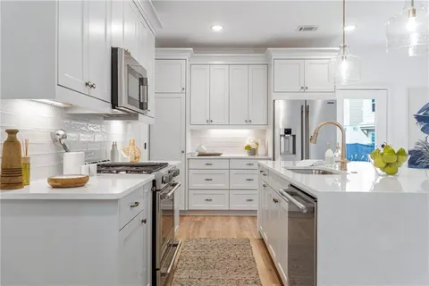 a kitchen with stainless steel appliances granite countertop a sink stove and cabinets