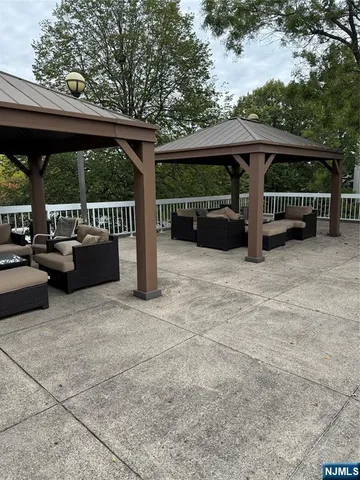 a view of roof deck with table and chairs a barbeque