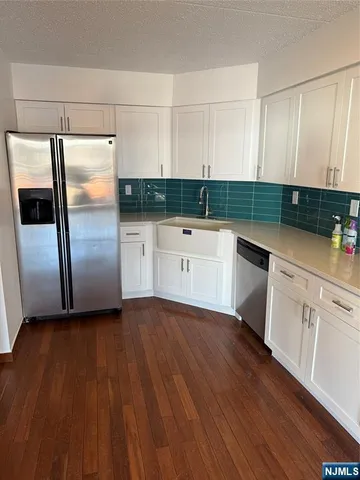 a kitchen with a refrigerator sink and cabinets
