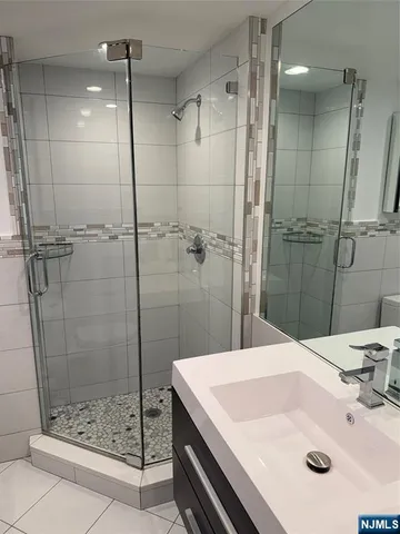 a bathroom with a sink shower and a mirror