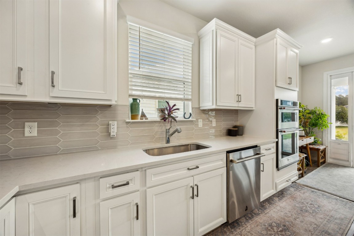 368 Muhly Grass Street Yulee, FL 32097 - Photo 17 of 60 a kitchen with stainless steel appliances white cabinets and a sink